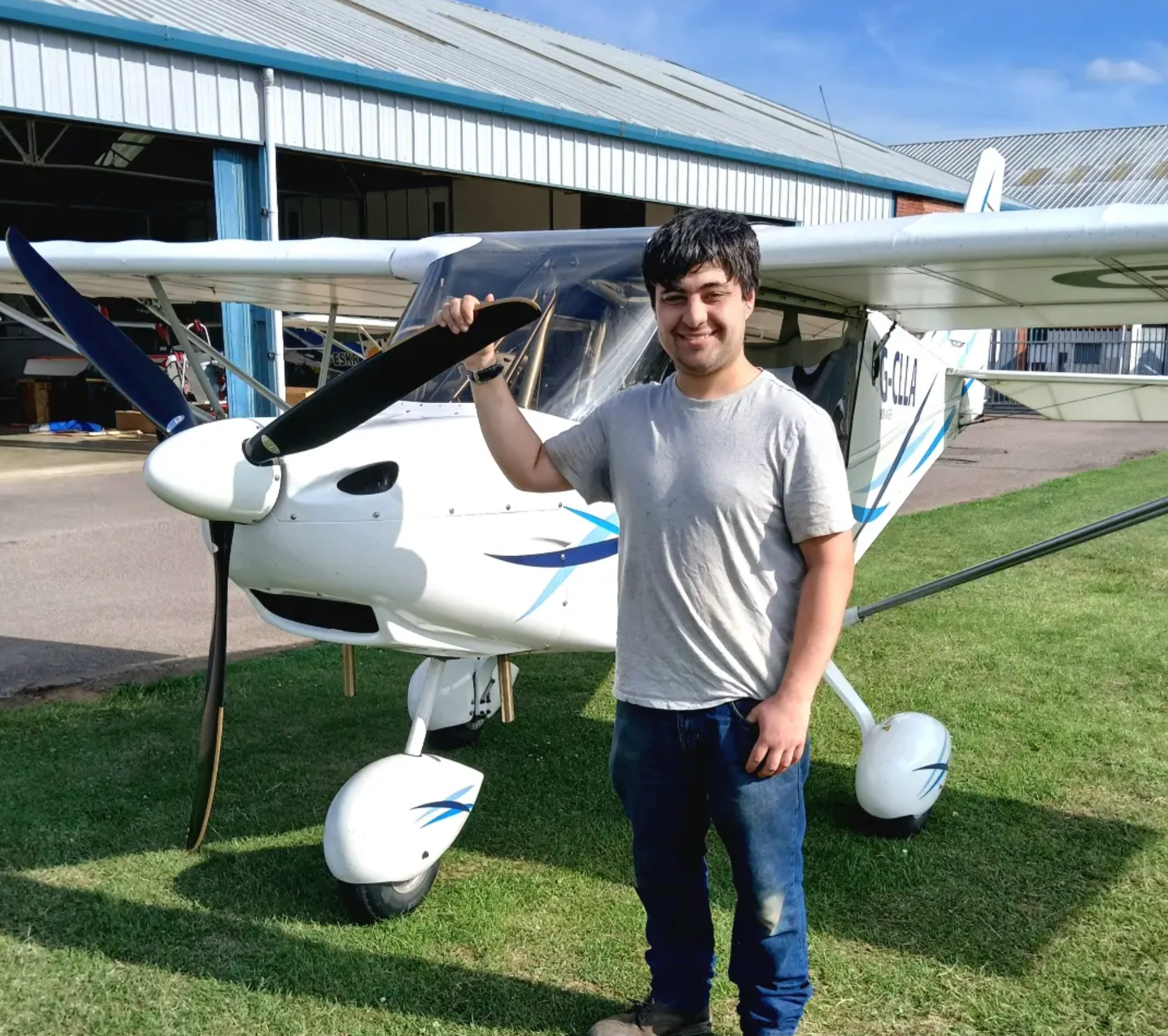 Smiling student beside a microlight